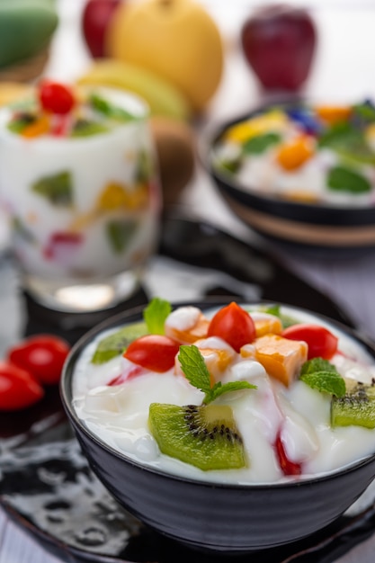 Foto gratuita ensalada de frutas en un recipiente en el piso de madera.