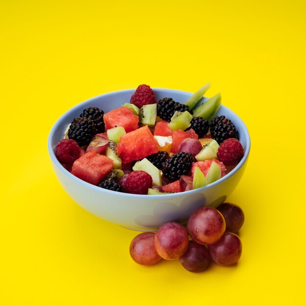 Ensalada de frutas sabrosas sobre fondo amarillo