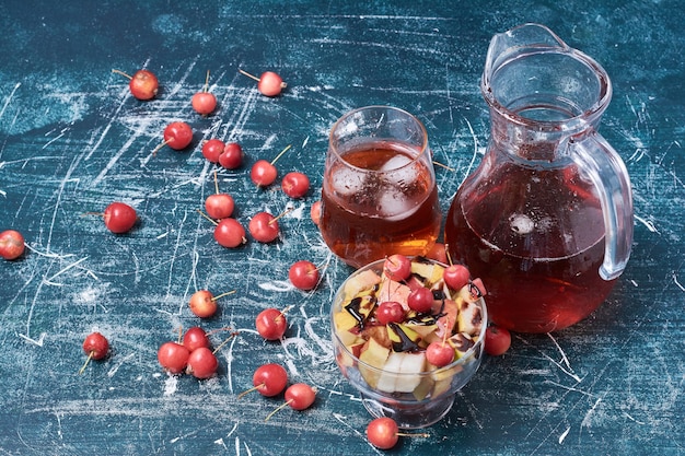 Ensalada de frutas con una taza de bebida en azul.