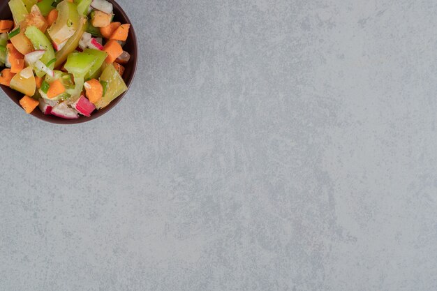 Ensalada de frutas en una taza de madera sobre una superficie de hormigón