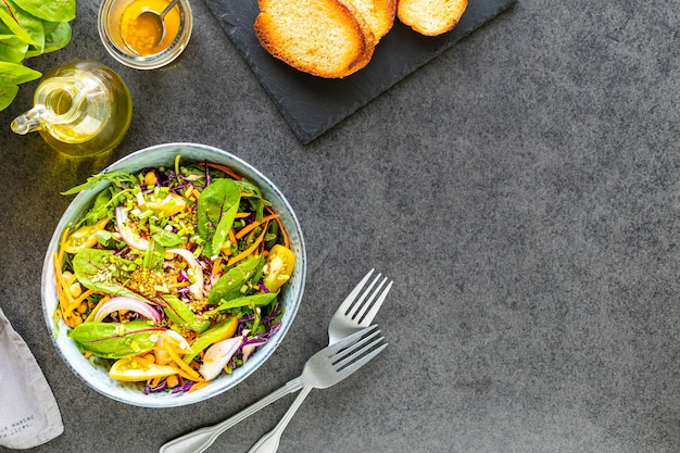 Ensalada de frutas y verduras frescas en un plato sobre la superficie de piedra negra