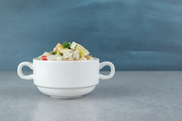 Ensalada de frutas y verduras de ingredientes mixtos en una taza blanca.