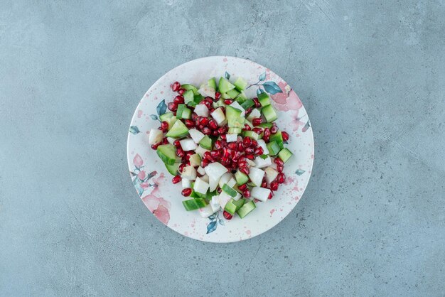 Ensalada de frutas y verduras picadas en un plato.