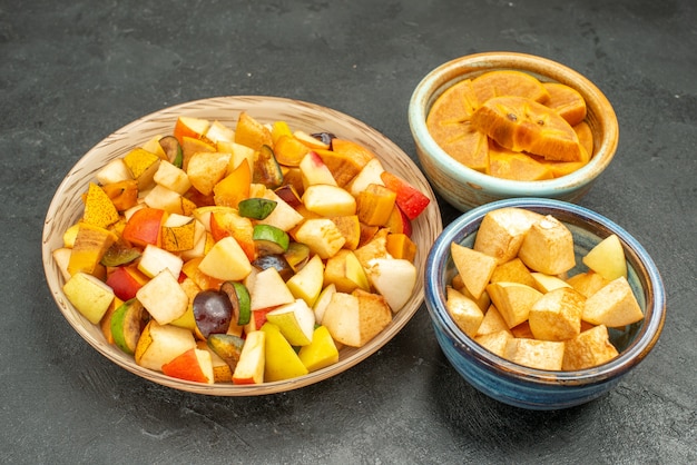 Ensalada de frutas vista frontal con frutas frescas en rodajas en la mesa gris fruta de árbol fresca