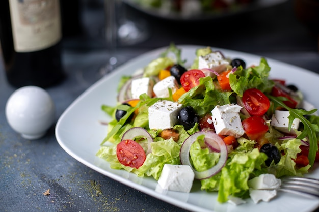 Ensalada de Grecia aceitunas en rodajas vino tinto dentro de plato blanco