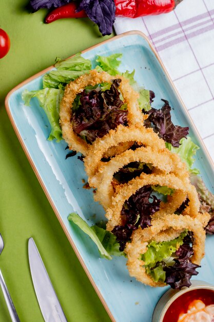 Ensalada de hierbas con aros de cebolla frita