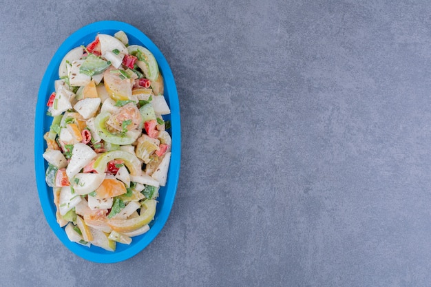 Ensalada con hierbas y verduras picadas sobre superficie de hormigón