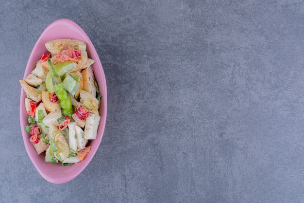 Ensalada con hierbas y verduras picadas sobre superficie de hormigón