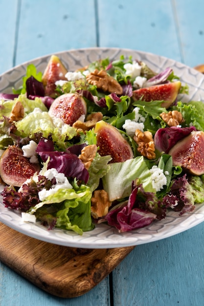 Foto gratuita ensalada de higos con queso y nueces sobre mesa de madera azul