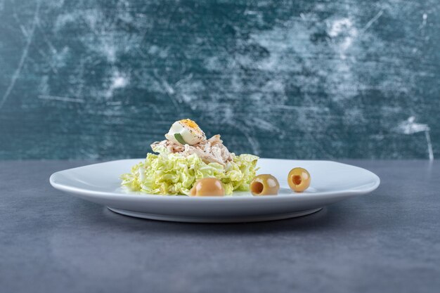 Ensalada de huevo y pollo hervido en plato blanco.