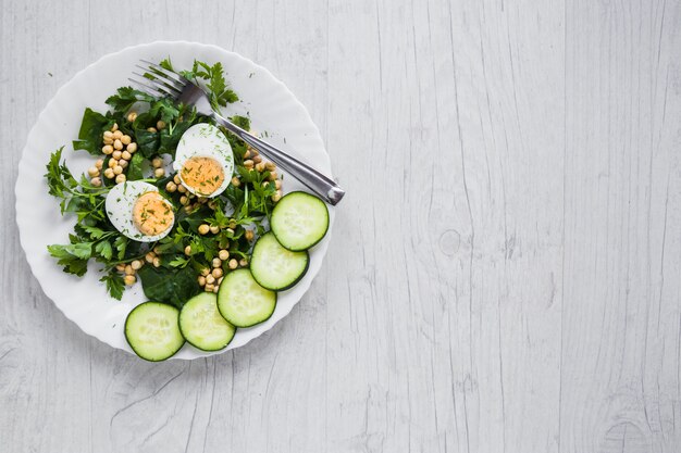 Ensalada con huevo sobre fondo blanco