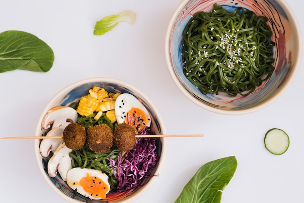 Ensalada japonesa de algas chuka con fideos sobre fondo blanco