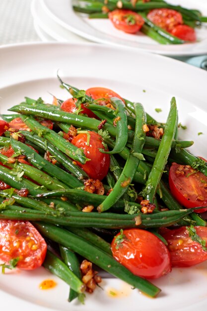 Ensalada de judías verdes y tomate en plato blanco