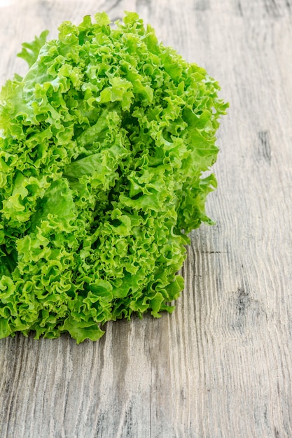 Foto gratuita ensalada de lechuga en una pared de madera