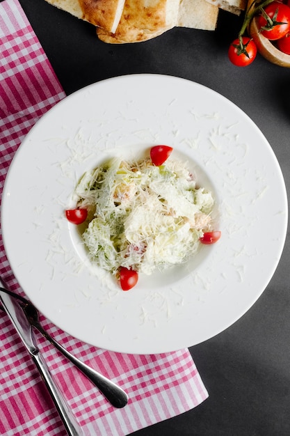 Ensalada con lechuga de pollo, tomates y queso rallado