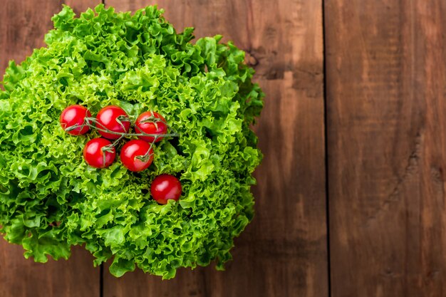 Ensalada de lechuga y tomates cherry en una pared de madera