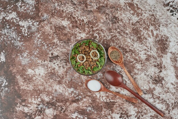 Ensalada de lentejas verdes con hierbas y cebollas en un vaso