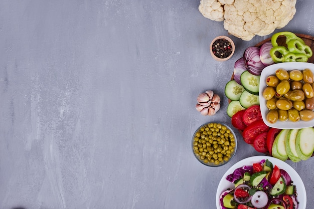 Foto gratuita ensalada ligera con verduras y hierbas en platos blancos.