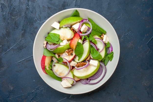 Ensalada de manzana fresca vista superior en un tazón de fondo azul oscuro