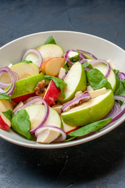 Ensalada de manzana vista inferior en un tazón sobre la mesa aislada oscura