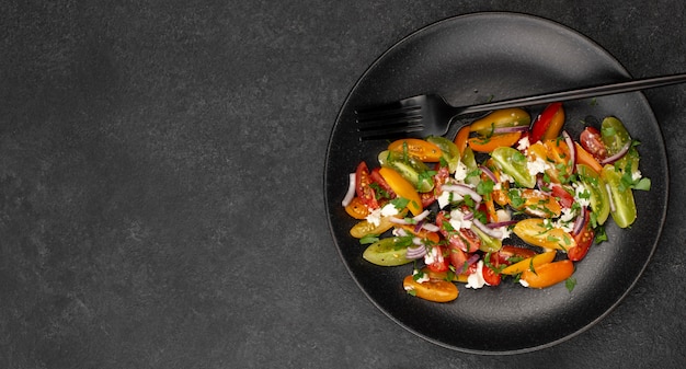 Ensalada de mezcla de tomate plano laico con queso feta, rúcula y espacio de copia