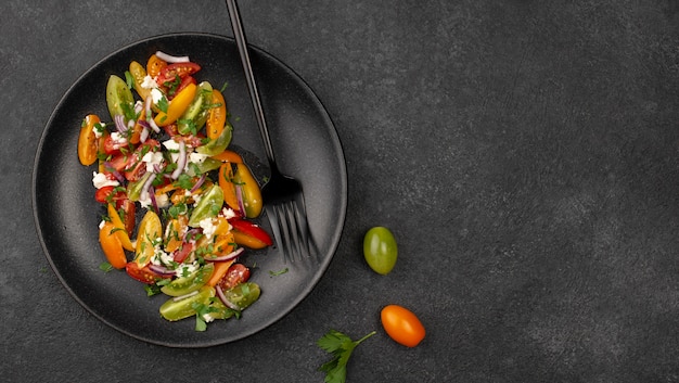 Ensalada de mezcla de tomate vista superior con queso feta, rúcula y espacio de copia