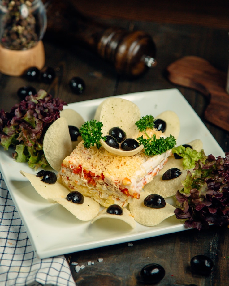 Foto gratuito ensalada de mimosa adornada con patatas fritas y aceitunas