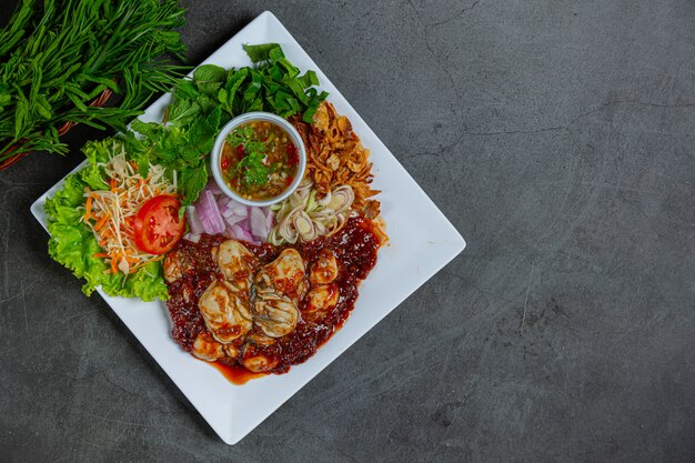 Ensalada de ostras frescas picantes e ingredientes alimentarios tailandeses.