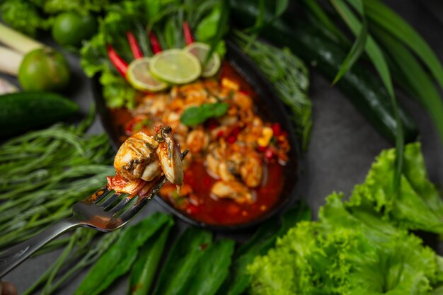 Ensalada de ostras frescas picantes e ingredientes de comida tailandesa