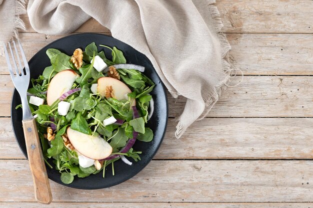 Ensalada de otoño con manzanas y nueces en una mesa de madera