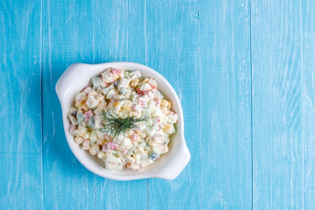 Foto gratuita ensalada con palitos de cangrejo, huevos, maíz y pepino.