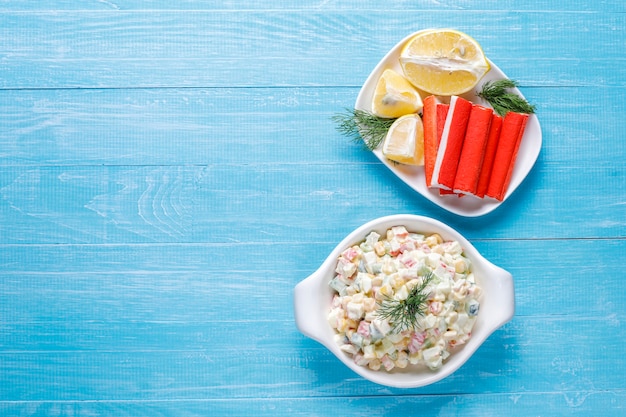 Foto gratuita ensalada con palitos de cangrejo, huevos, maíz y pepino.