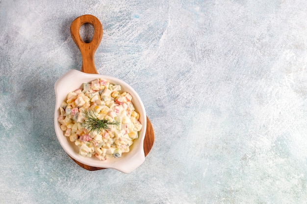 Foto gratuita ensalada con palitos de cangrejo, huevos, maíz y pepino.