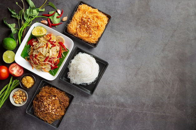 Ensalada de papaya servida con fideos de arroz y ensalada de verduras Decorada con ingredientes de la comida tailandesa.