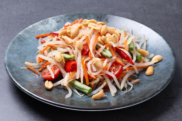 Foto gratuita ensalada de papaya verde som tam thai sobre fondo de pizarra negra