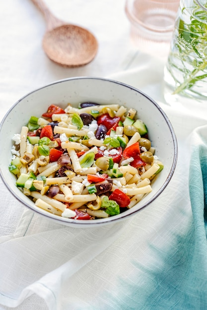 Ensalada de pasta de macarrones con queso feta y aceitunas, plato de verano griego saludable