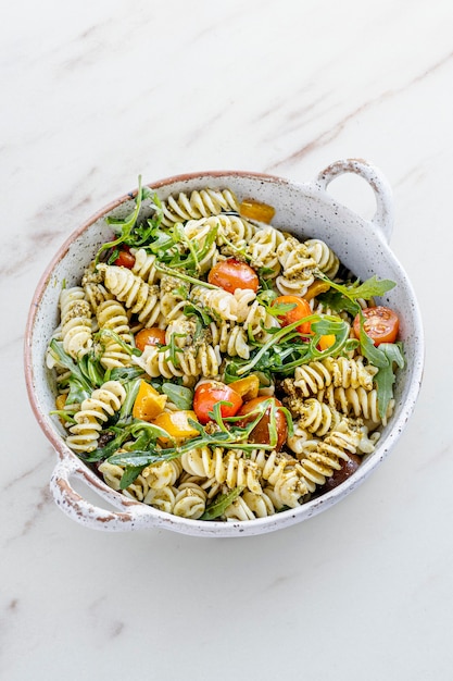 Ensalada de pasta rotini con rúcula y tomates cherry, plato de verano saludable