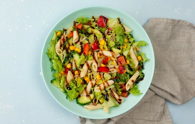 Ensalada de pasta vista superior con vinagre balsámico y paño de cocina