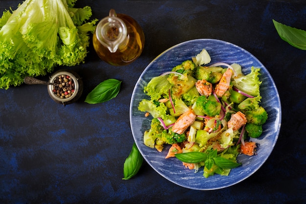 Ensalada de pescado guisado salmón, brócoli, lechuga y aderezo. Menú de pescado Menú dietético Mariscos - salmón. Vista superior