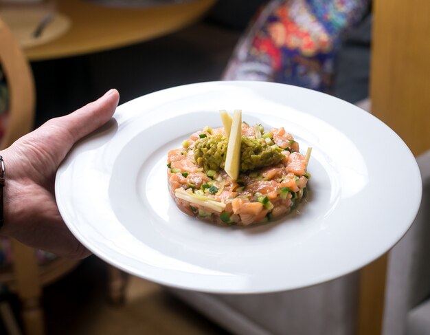 Ensalada de pescado salmón pepino manzana puré de aguacate vista lateral