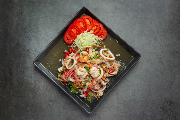 Ensalada picante de mariscos mixtos con ingredientes de comida tailandesa.