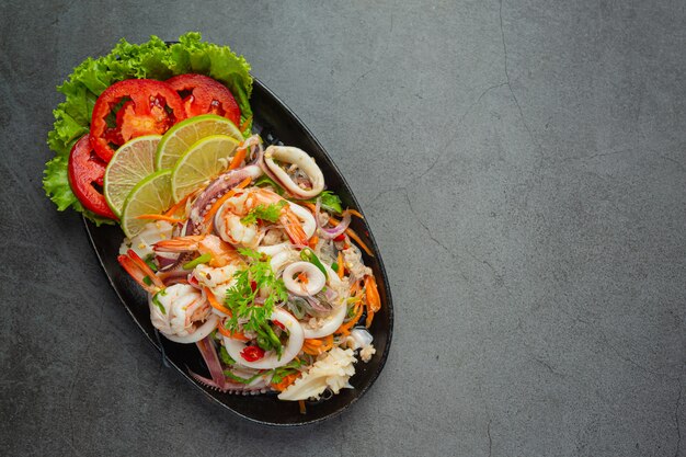 Ensalada picante de mariscos mixtos con ingredientes de comida tailandesa.