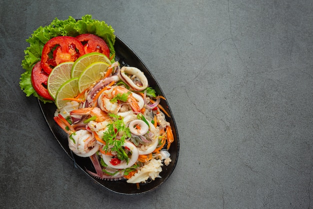 Ensalada picante de mariscos mixtos con ingredientes de comida tailandesa.