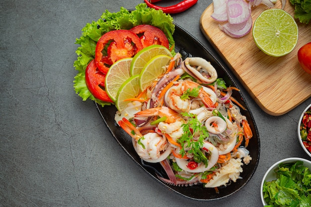 Ensalada picante de mariscos mixtos con ingredientes de comida tailandesa.
