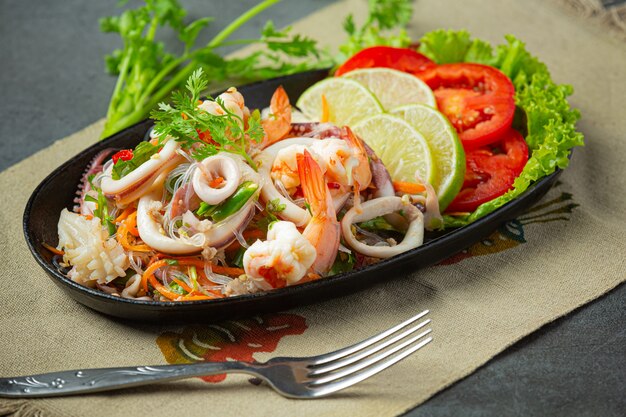 Ensalada picante de mariscos mixtos con ingredientes de comida tailandesa.