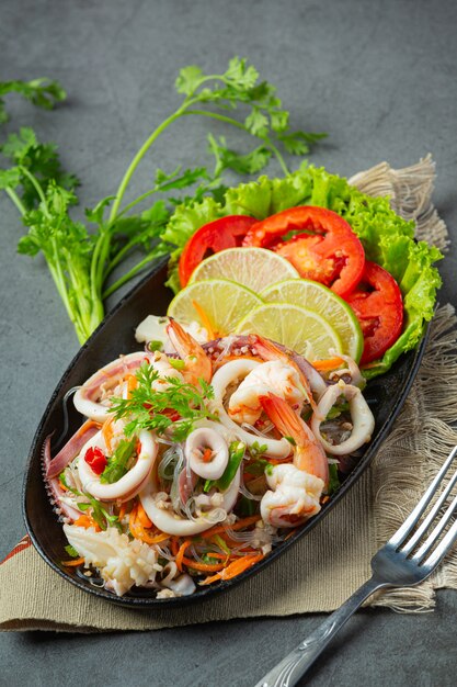 Ensalada picante de mariscos mixtos con ingredientes de comida tailandesa.