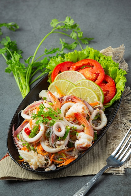 Ensalada picante de mariscos mixtos con ingredientes de comida tailandesa.