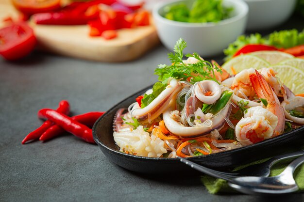 Ensalada picante de mariscos mixtos con ingredientes de comida tailandesa.