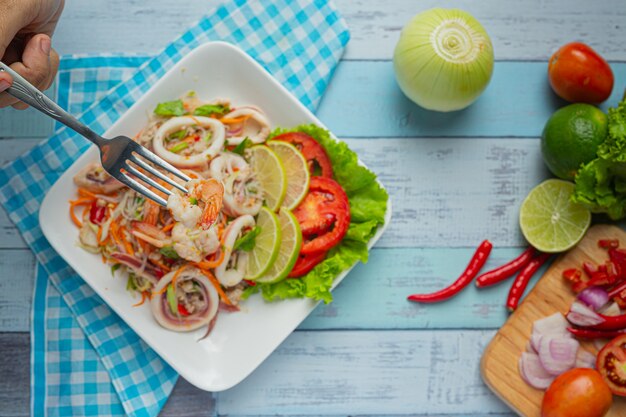 Ensalada picante de mariscos mixtos con ingredientes de comida tailandesa.