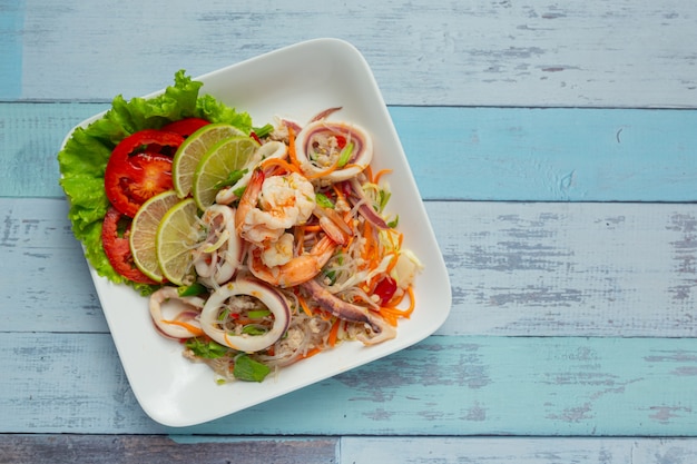 Ensalada picante de mariscos mixtos con ingredientes de comida tailandesa.